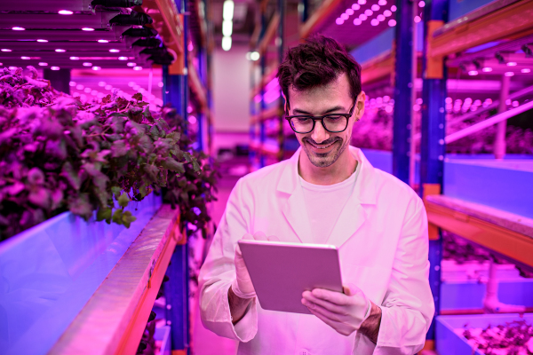 Portrait of worker with tablet on aquaponic farm, sustainable business and artificial lighting.