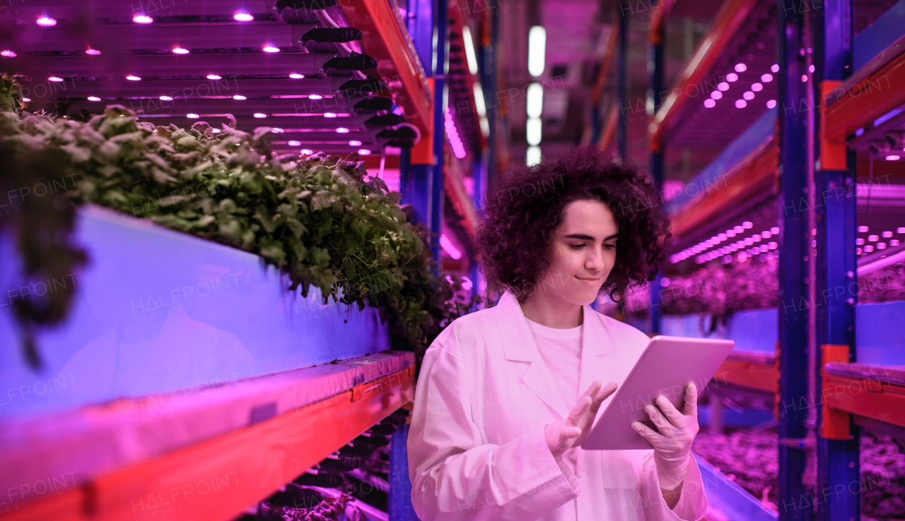 Portrait of worker with tablet on aquaponic farm, sustainable business and artificial lighting.