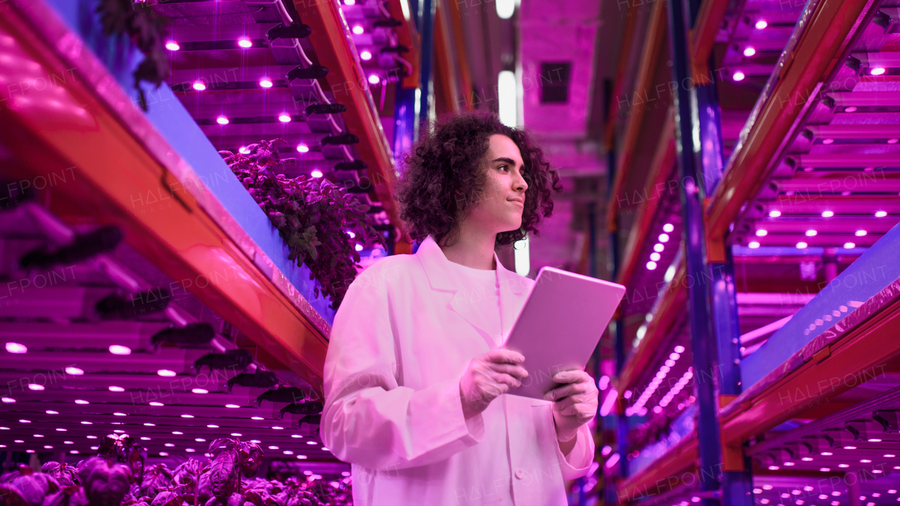 Portrait of worker with tablet on aquaponic farm, sustainable business and artificial lighting.