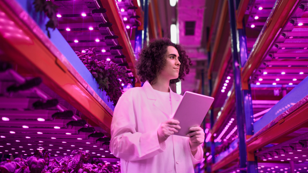 Portrait of worker with tablet on aquaponic farm, sustainable business and artificial lighting.