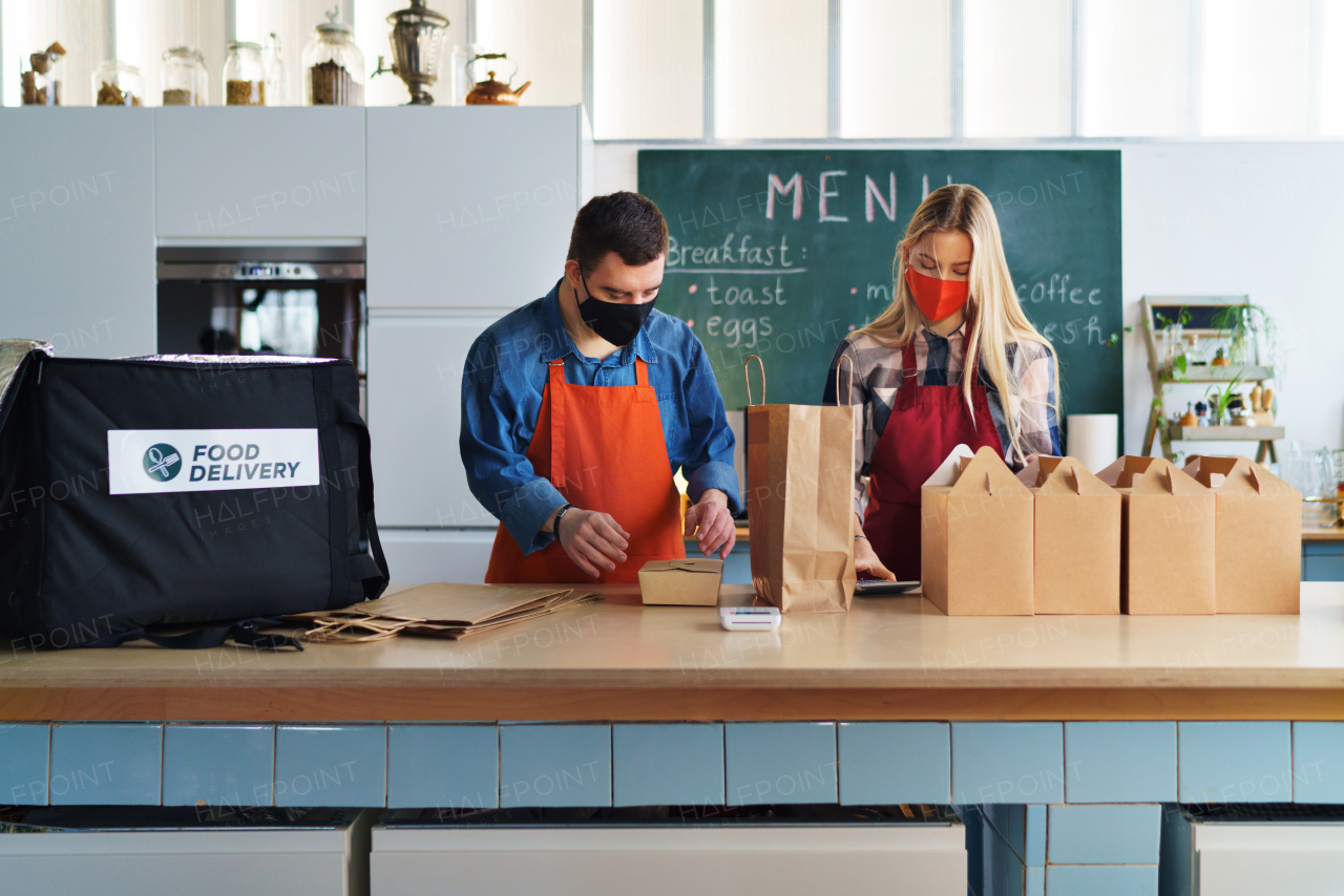 A young Down Syndrome waiter working with colleague in take away restaurant, social inclusion concept.