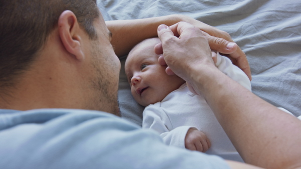 A close up of young father enjoying time together with newborn baby girl at home.