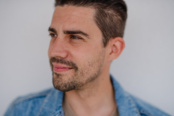 Portrait of a young caucasian man on white background, looking aside.