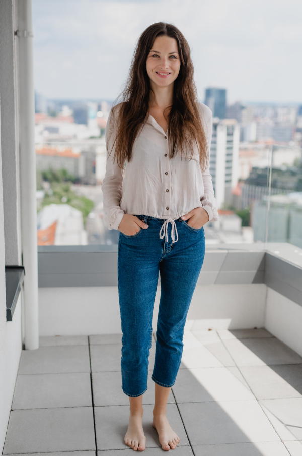 A portrait of young caucasian woman outdoors, looking at camera.