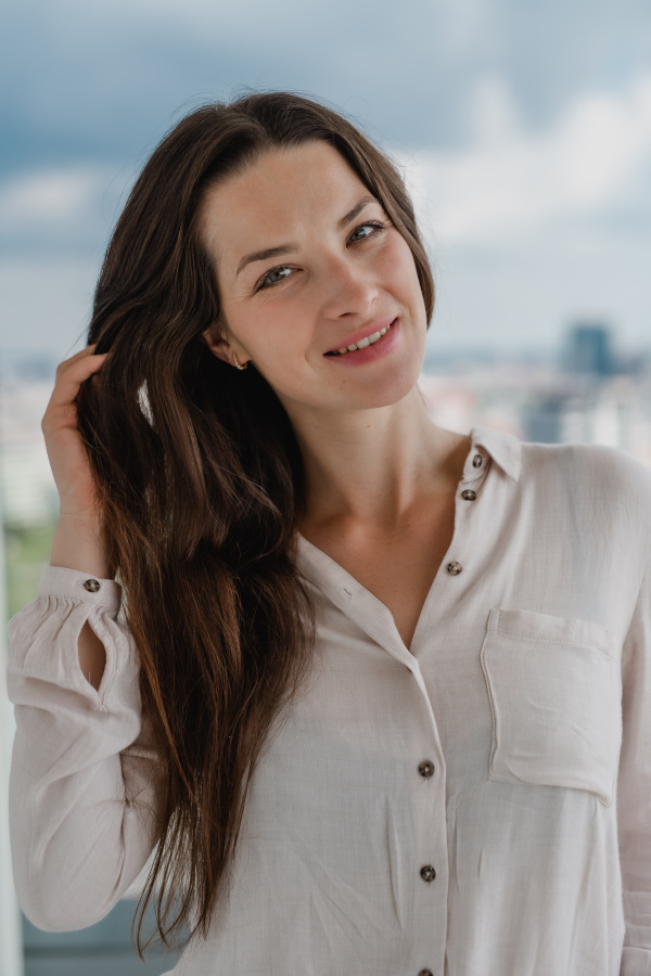 A portrait of young caucasian woman outdoors, looking at camera.