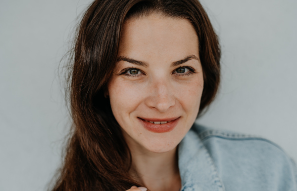 A close up of happy young caucasian woman on white background, smiling.