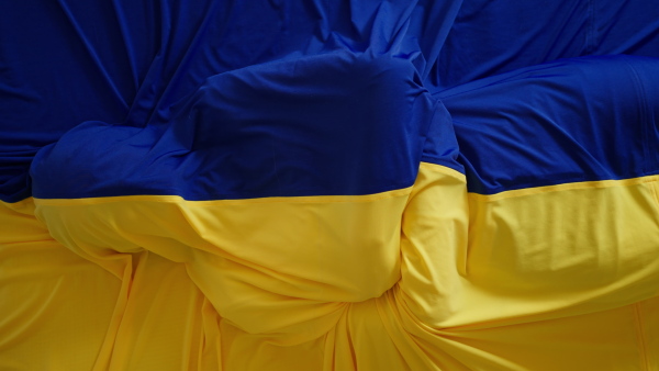 A person lying under Ukrainian flag, unity with Ukraine concept.