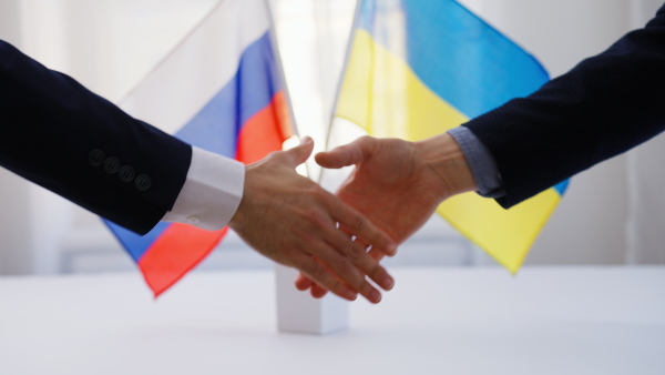 The representatives of Ukraine and Russia shaking hands, Ukraine peace agreement concept.