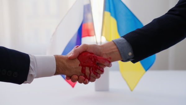 The representatives of Ukraine and Russia shaking hands, Ukraine peace agreement concept.