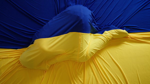 A person lying under Ukrainian flag, unity with Ukraine concept.