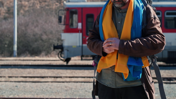 A depressed Ukrainian man touching his wedding ring and leaving his family due to war.