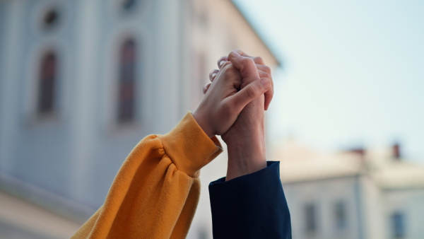 People holding hands and protesting against a Russian invasion in Ukraine in streets.