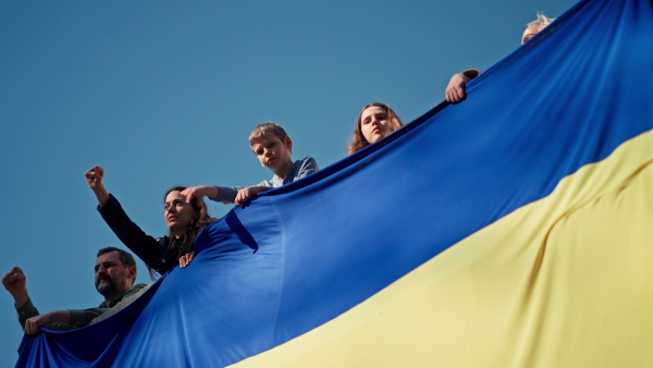 People raising hands and protesting against Russian invasion in Ukraine in streets, a low angle view.