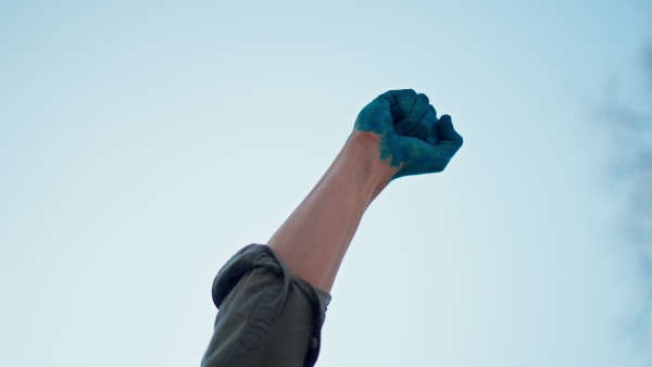 A man with painted hand in blue protesting against Russian invasion in Ukraine in streets, close-up.