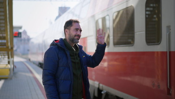 An Ukrainian man saying good bye and waving to his family in train leaving Ukraine due to Russian invasion in Ukraine.