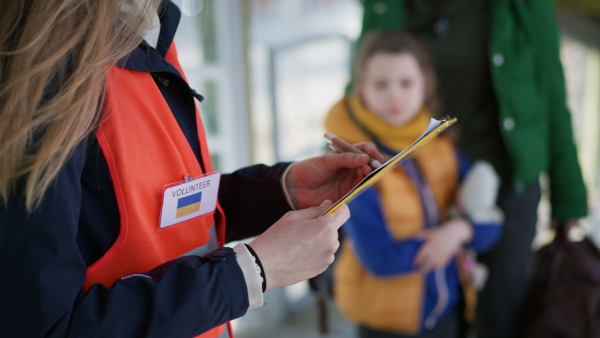 A volunteer registring Ukrainian refugees at train station.