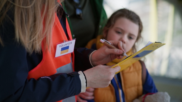 A volunteer registring Ukrainian refugees at train station.