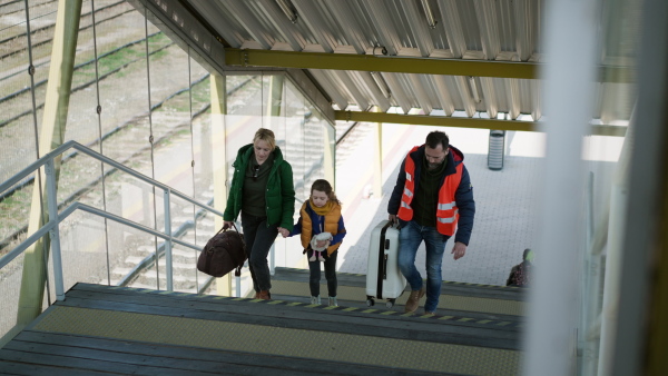 A volunteer helping Ukrainian mother with child, refugees, at train station.