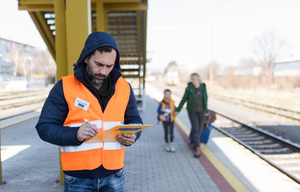 A volunteer registring Ukrainian refugees at train station.