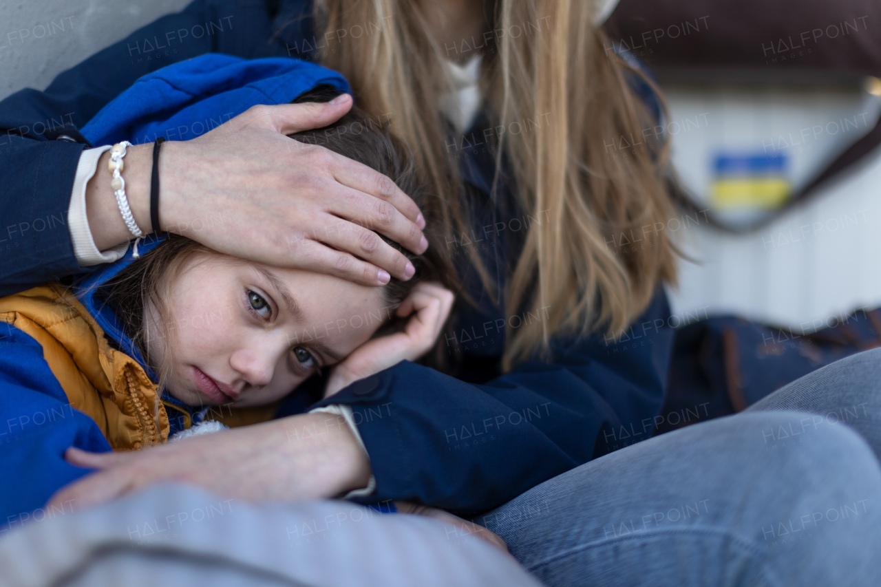 Depressed Ukrainian immigrants sitting and waiting at a railway station.