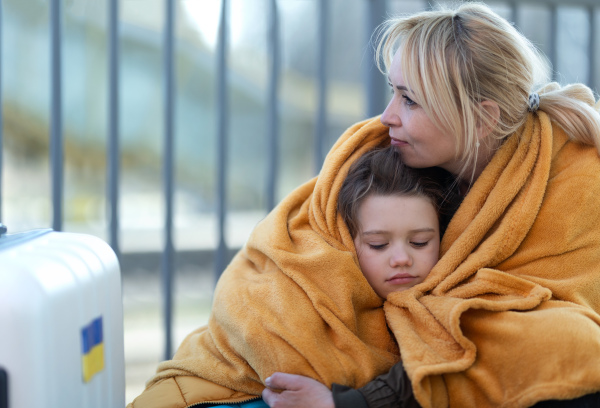 Depressed Ukrainian immigrants sitting and waiting at a railway station.