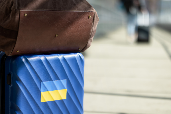 A suitcase on railway. Stand with Ukraine. Ukrainian people leaving from the war. Ukrainian refugees concept.