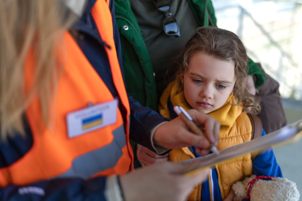 A volunteer registring Ukrainian refugees at train station.