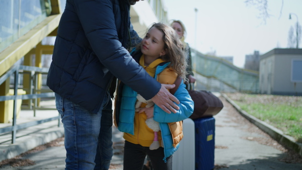 A close-up of Ukrainian girl hugging her father and saying goodbye before leaving, Ukrainian war concept.