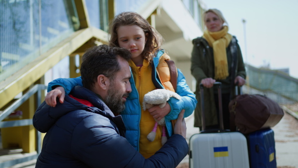 A close-up of Ukrainian girl hugging her father and saying goodbye before leaving, Ukrainian war concept.