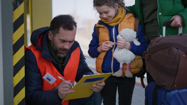 A volunteer registring Ukrainian refugees at train station.