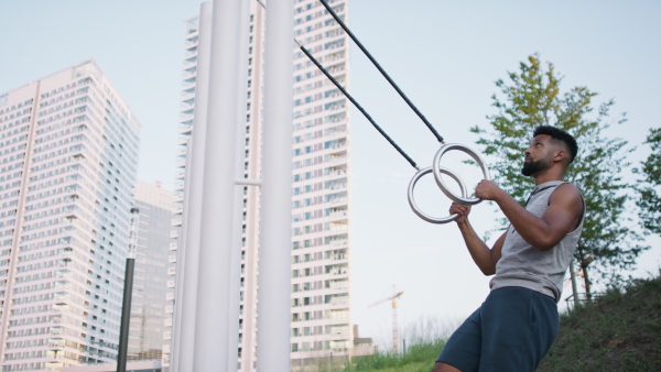 A young man doing exercise outdoors in city, healthy lifestyle concept.