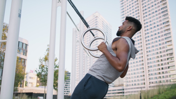 A young man doing exercise outdoors in city, healthy lifestyle concept.