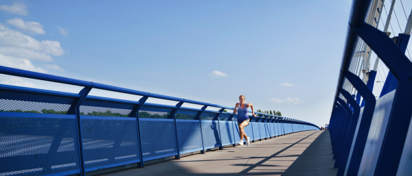 A mid adult woman running outdoors in city, healthy lifestyle concept.