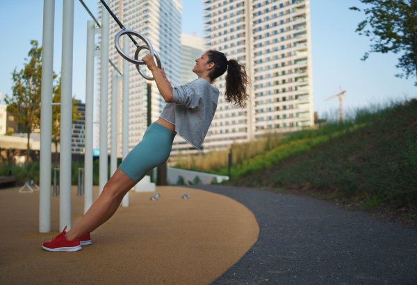 Mid adult woman doing exercise on a mat outdoors in city, healthy lifestyle concept.