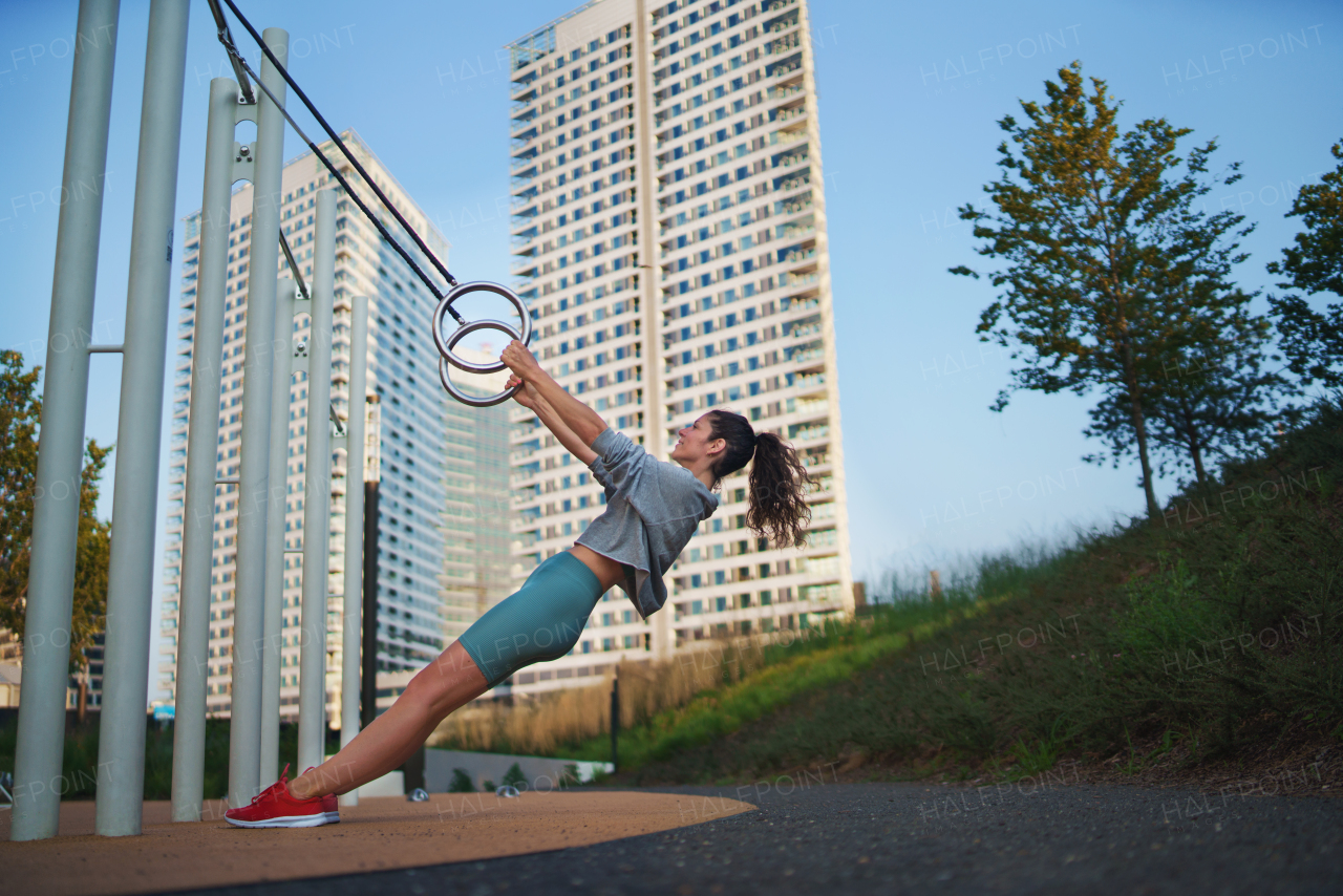 Mid adult woman doing exercise on a mat outdoors in city, healthy lifestyle concept.