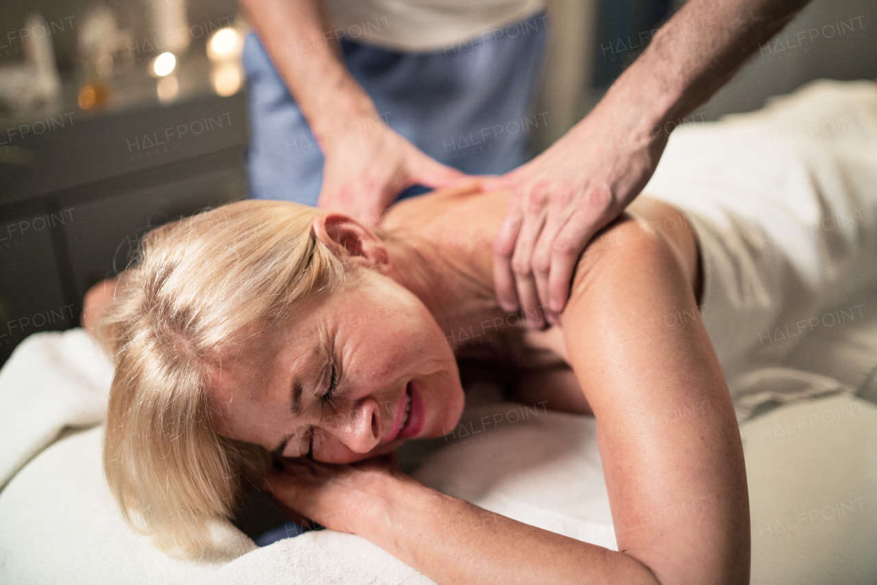 Senior woman having relaxing back massage at the spa.