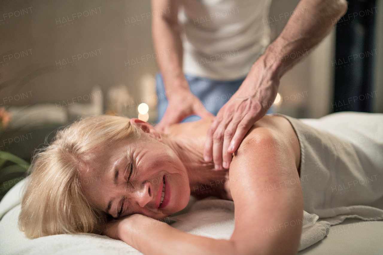 Senior woman having relaxing back massage at the spa.