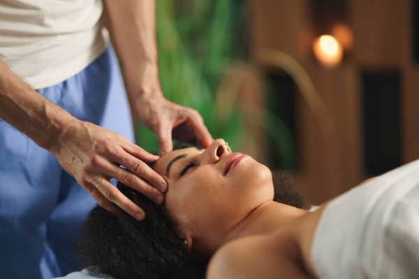 A young woman having relaxing head massage at the spa.