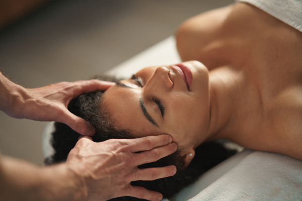 Young woman having relaxing head massage at the spa.