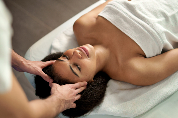 A top view of young woman having relaxing head massage at the spa.