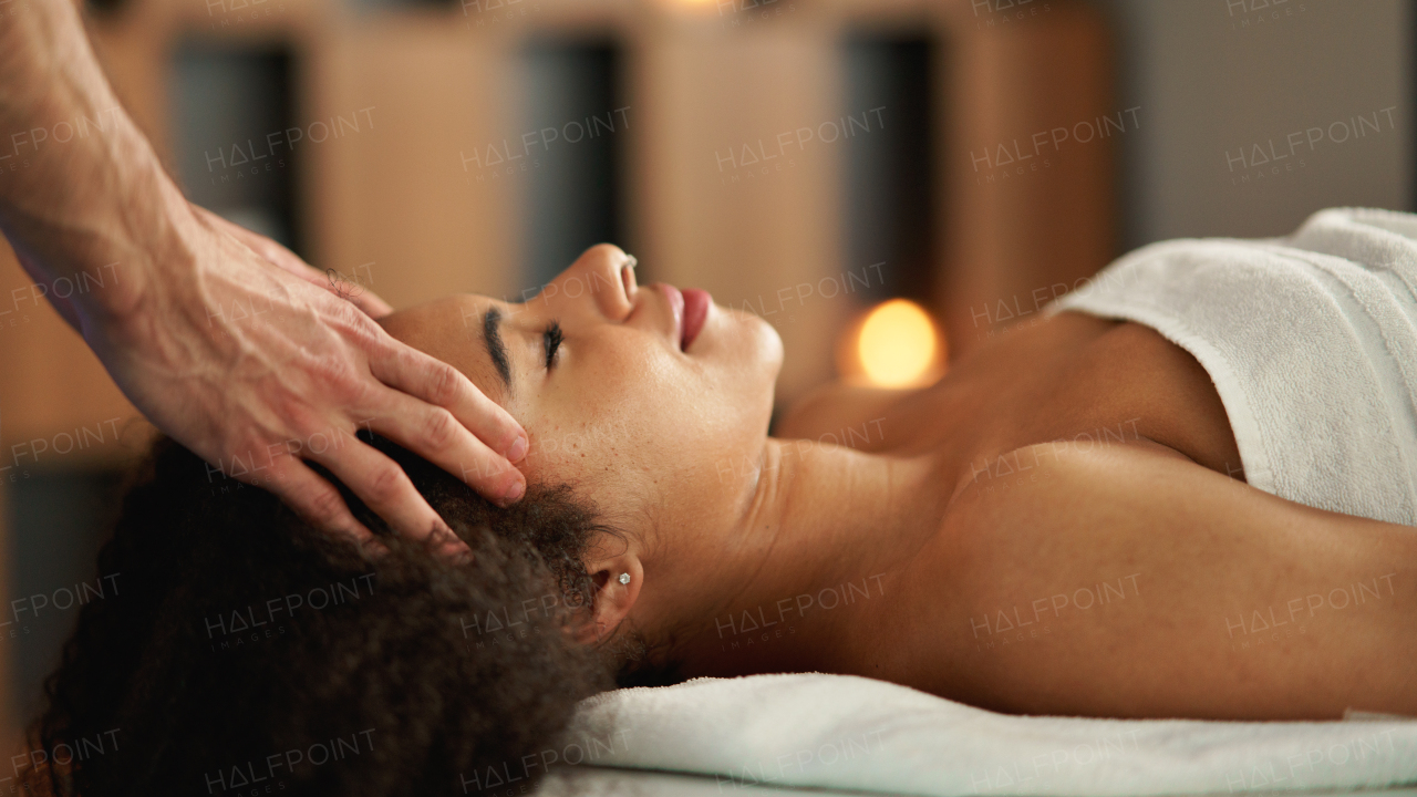 Young woman having relaxing head massage at the spa.