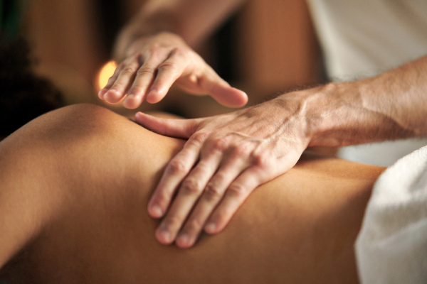 Unrecognizable young woman having relaxing back massage at the spa.