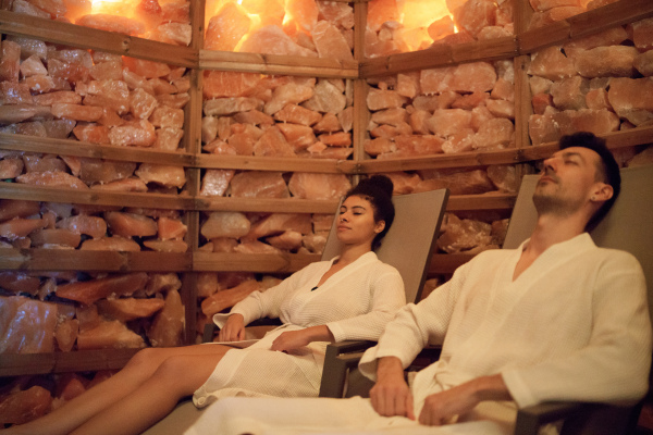 Portrait of happy young couple in salt inhalation steam room, relaxing.