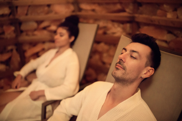 Portrait of happy young couple in salt inhalation steam room, relaxing.