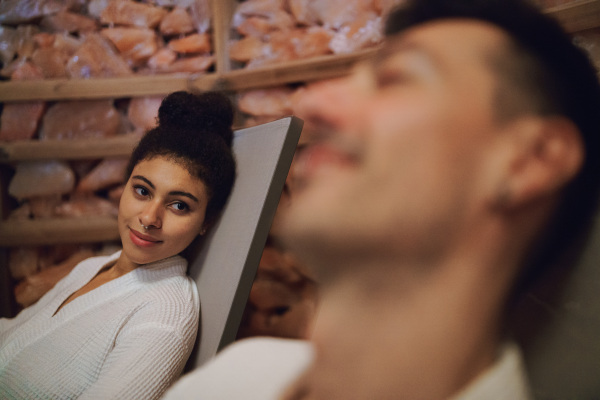 Portrait of happy young couple in salt inhalation steam room, relaxing.