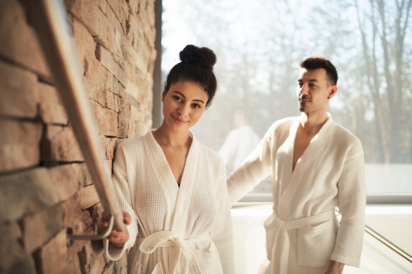 Portrait of happy young couple in spa resort, walking up the stairs.