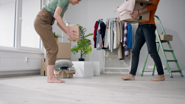 Happy young couple with boxes moving in new flat, new home and relocation concept.