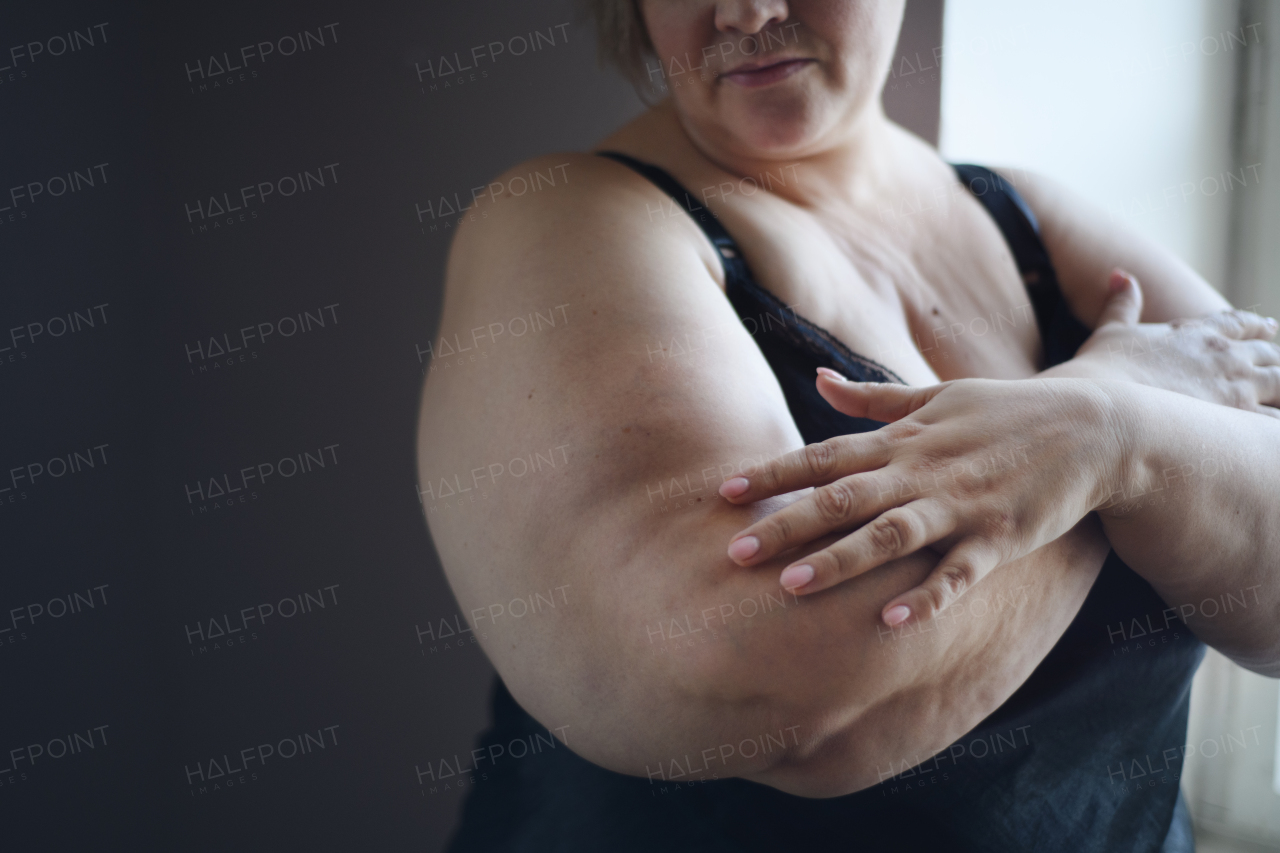 A sad lonely fat woman in underwear at home.