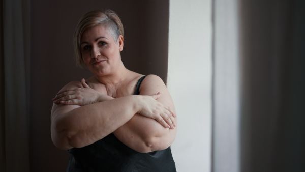 A happy lonely fat woman in underwear at home.