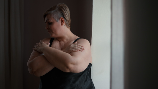 A depressed lonely fat woman in underwear at home.